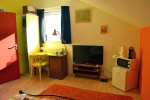 - un salon avec une télévision et une table avec un bureau dans l'établissement Harry's Home Tiel Bed & Breakfast, à Norwich