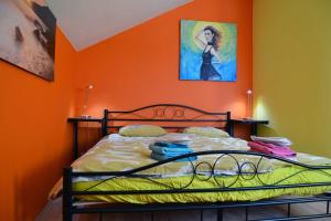 a bedroom with a bed with an orange wall at Harry's Home Tiel Bed & Breakfast in Tiel