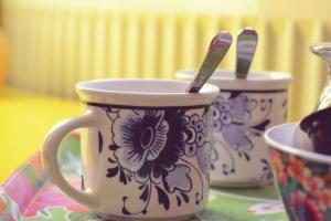 due tazze con utensili seduti su un tavolo di Harry's Home Tiel Bed & Breakfast a Tiel