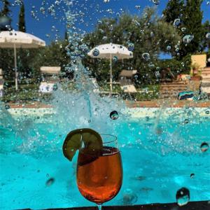 a drink sitting next to a swimming pool at La Compagnia del Chianti in San Donato in Poggio