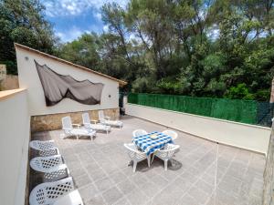 un patio con mesa, sillas y una valla en Villa Cala Santanyí Beach House JM by Interhome, en Santanyí
