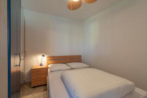 ein kleines Schlafzimmer mit einem Bett und einem Nachttisch in der Unterkunft Wijde Blick appartement 208 - Callantsoog in Callantsoog