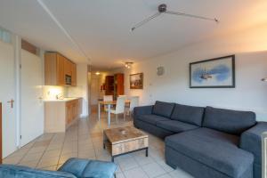 ein Wohnzimmer mit einem Sofa und einem Tisch in der Unterkunft Wijde Blick appartement 208 - Callantsoog in Callantsoog