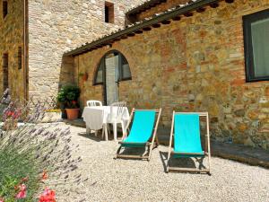 two blue chairs and a table in front of a building at Holiday Home Cieloterra e Veranda by Interhome in Gambassi Terme