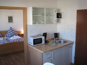 a small kitchen with a sink and a microwave at Central Wohnen in Wilhelmshaven