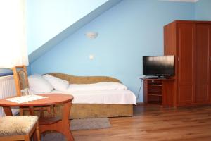 sypialnia z łóżkiem, telewizorem i stołem w obiekcie Hotel Czardasz we Wrześni