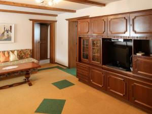 Una sala de estar con un gran centro de entretenimiento y un televisor. en Apartment Martina-1 by Interhome, en Pfunds
