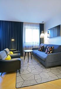 - un salon avec un canapé, un lit et une table dans l'établissement Hôtel Le Roosevelt Lyon, à Lyon