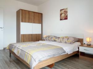 sypialnia z dużym łóżkiem z drewnianym zagłówkiem w obiekcie Apartment Rosić - KRK217 by Interhome w mieście Kornić