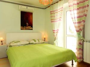 a bedroom with a green bed and a window at Holiday Home Mateja - KRK228 by Interhome in Kornić