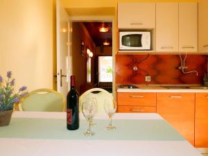 a bottle of wine sitting on a table with two wine glasses at Apartment Ana - RAB165 by Interhome in Rab