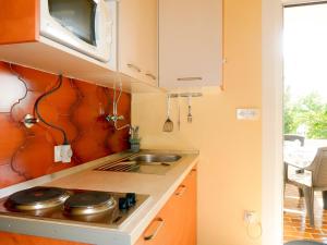 a small kitchen with a sink and a microwave at Apartment Ana - RAB165 by Interhome in Rab