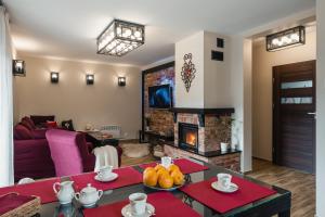 a living room with a table and a fireplace at Ostoja Zaskalskie Apartament Rubin 52 metry in Jaworki
