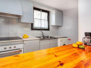 een keuken met een houten tafel met fruit erop bij Apartment Ducado Golf CII by Interhome in Pals
