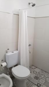 La salle de bains blanche est pourvue d'une douche et de toilettes. dans l'établissement Espectacular Depto a 2 cuadras del río! A Nuevo!!, à Rosario