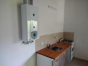 een kleine keuken met een spoelbak en een fornuis bij El diquecito monoambiente in Casa Bamba