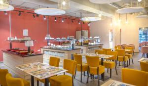 a restaurant with tables and chairs and a counter at SOWELL RESIDENCES Chênes Verts in Saint-Raphaël