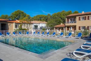 a swimming pool with lounge chairs and a swimming pool at SOWELL RESIDENCES Chênes Verts in Saint-Raphaël