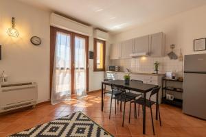 una cucina con tavolo, sedie e frigorifero di Montenero - B a Olbia