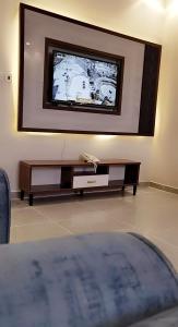 a living room with a flat screen tv on a wall at Marina Arar Furnished Apartments in Arar