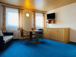 Pfarrweisach的住宿－祖姆高登阿德勒旅館，配有桌椅和沙发的房间