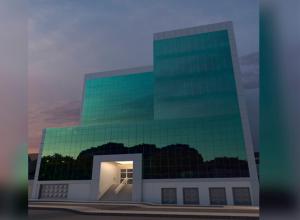 a large building with a green glass facade at Status Hotel in Río Grande