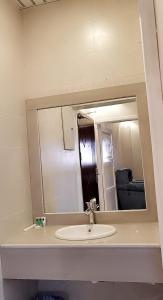a bathroom with a sink and a mirror at Marina Arar Furnished Apartments in Arar