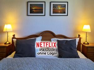 a bedroom with a bed with a netflix inclusive online login pillow at Landlust Hotel in Gransee