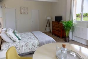 a bedroom with a bed and a table and a window at Clos de la source Gironde in Saint-Martin-du-Bois +7 photos