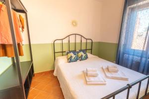 a small bedroom with a bed with towels on it at Montenero - B in Olbia
