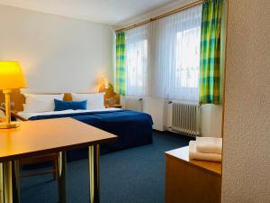 a hotel room with a bed and a desk at Zum Goldenen Adler in Pfarrweisach