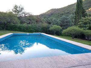 een blauw zwembad met een berg op de achtergrond bij El diquecito monoambiente in Casa Bamba