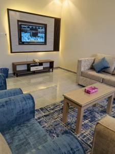 a living room with two couches and a table at Marina Arar Furnished Apartments in Arar