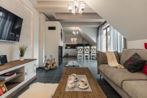 ein Wohnzimmer mit einem Sofa und einem Tisch in der Unterkunft Ostoja Zaskalskie Apartament Szafir 74 metry in Jaworki