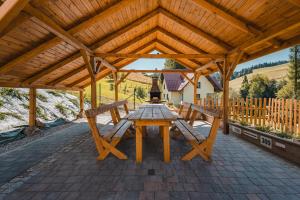 a wooden picnic table in a pavilion with two benches at Ostoja Zaskalskie Apartament Szafir 74 metry in Jaworki