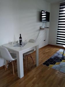 a white dining room table with a bottle of wine on it at Apartman Dunjica in Pale