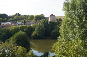 a view of a village with a lake and a church at Le Vieux Château de Saint Martin-Lars in Saint-Martin-Lars-en-Sainte-Hermine +10 photos
