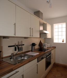 a kitchen with white cabinets and a sink at Hellinghaus FeWo 2 Klippenfänger in Wyk auf Föhr