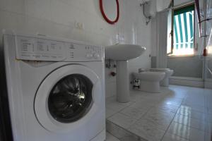 - un lave-linge blanc dans la salle de bains pourvue d'un lavabo dans l'établissement Residence On The Beach, à Vasto 37 autres photos