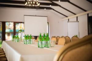 una mesa larga con botellas verdes y vasos. en Hotel Eljot, en Sielpia Wielka