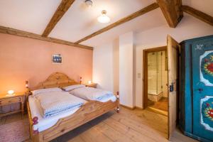 a bedroom with a wooden bed and a bathroom at Ferienwohnung Gschwand in Unterammergau
