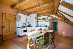 a kitchen with a wooden table and chairs at Ferienwohnung Gschwand in Unterammergau