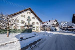 a house on a street with snow on the ground at Ferienwohnung Gschwand in Unterammergau