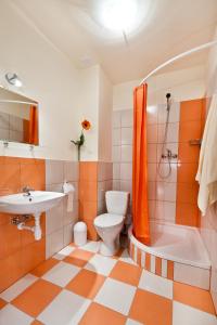 an orange and white bathroom with a toilet and a sink at Relax - usługi noclegowe in Łódź