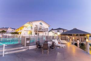 a house with a deck with chairs and a table at The BoatHouse in Marco Island