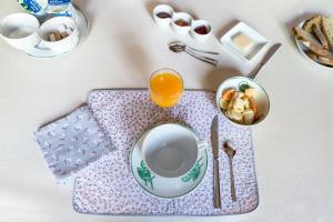 a table with a plate and a cup of orange juice at Les Glycines in Croix
