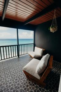 a couch and chair in a room with a view of the ocean at The Waves at Cane Bay in Kingshill