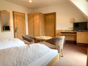 a hotel room with a bed and a table and a tv at Landhotel Bauernschmitt in Pottenstein