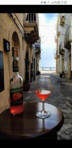 a bottle of alcohol and a wine glass on a table at Ortigia L'Antico Dammuso in Syracuse