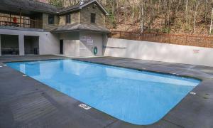 a large blue swimming pool in front of a house at Brentwood, Resort Pool, FREE Attraction tickets, Near Parkway, Hot Tub, Arcade Game, WIFI!!! in Pigeon Forge